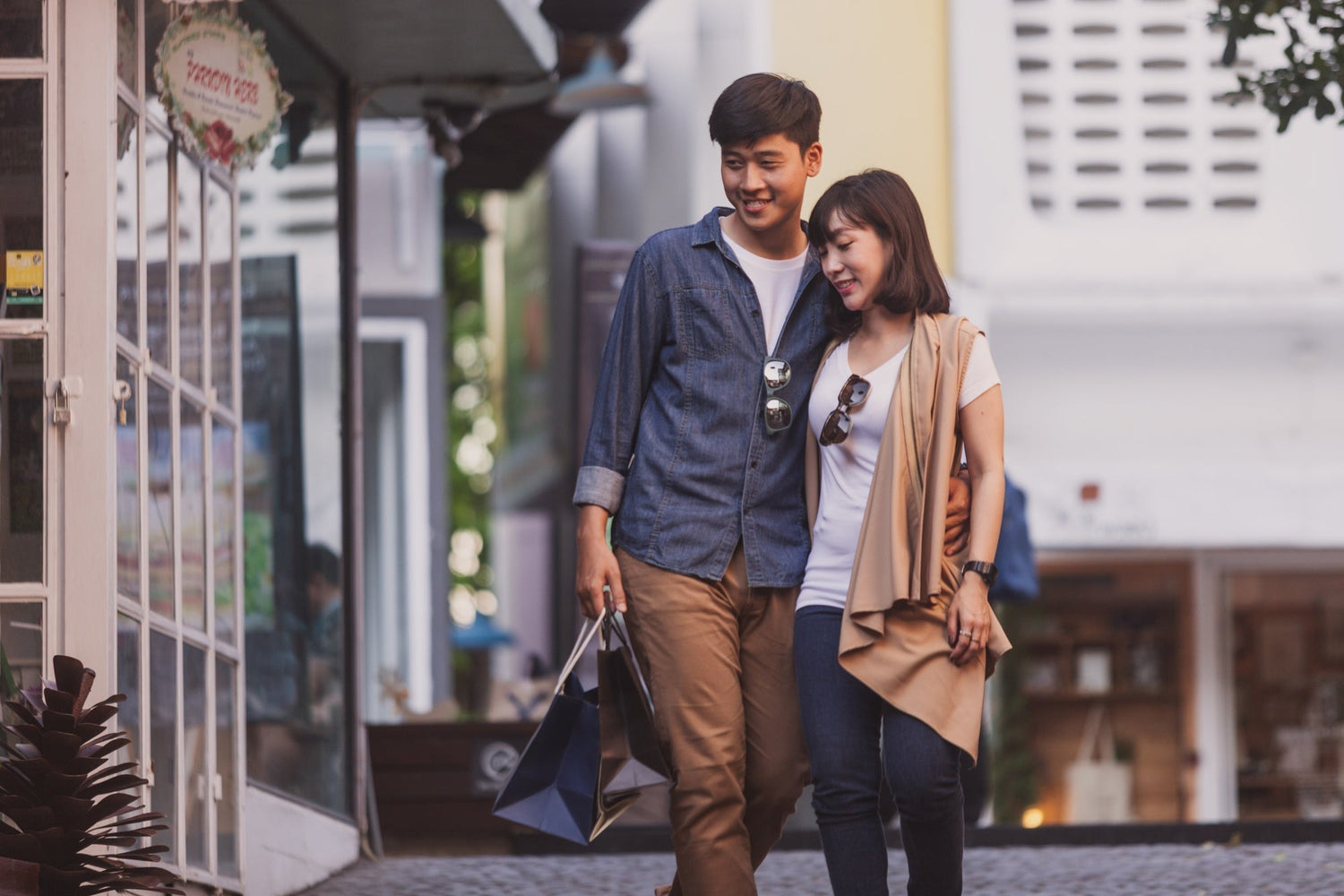 couple smiling as they walk toward a small neighborhood cafe