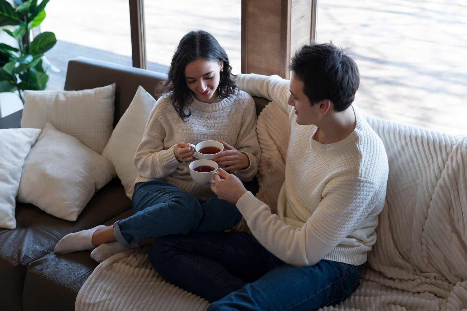 Two people on a couch, relaxed posture, warm lamplight, gentle smiles