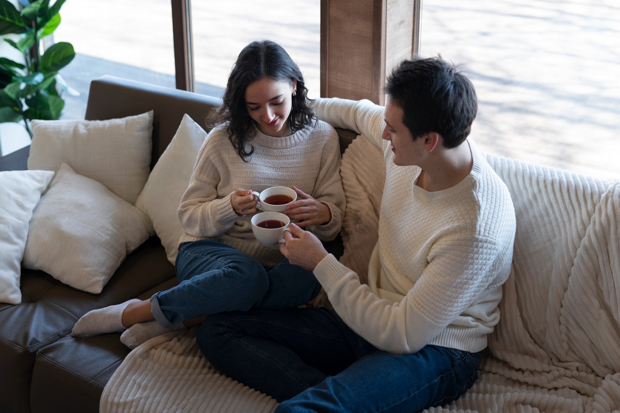 Two people on a couch, relaxed posture, warm lamplight, gentle smiles