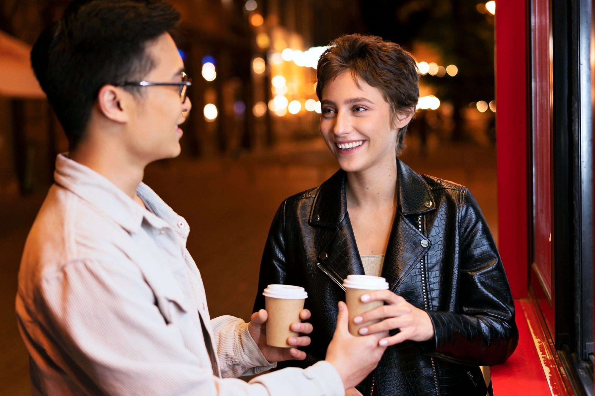 Two people walking out of a cafe, easy smiles, late afternoon light