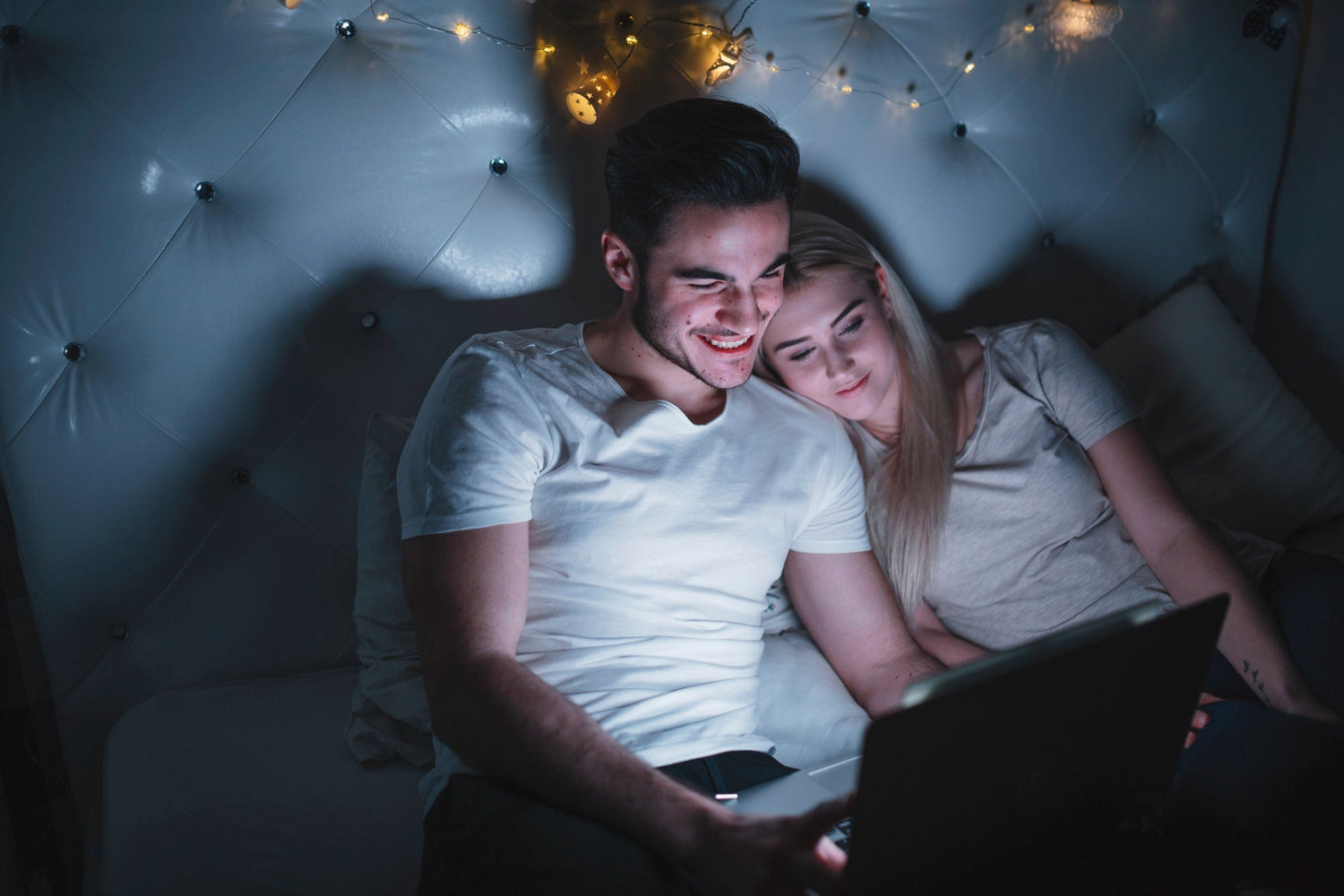 men and women laughing at a bedroom at night, soft window light, cozy mood