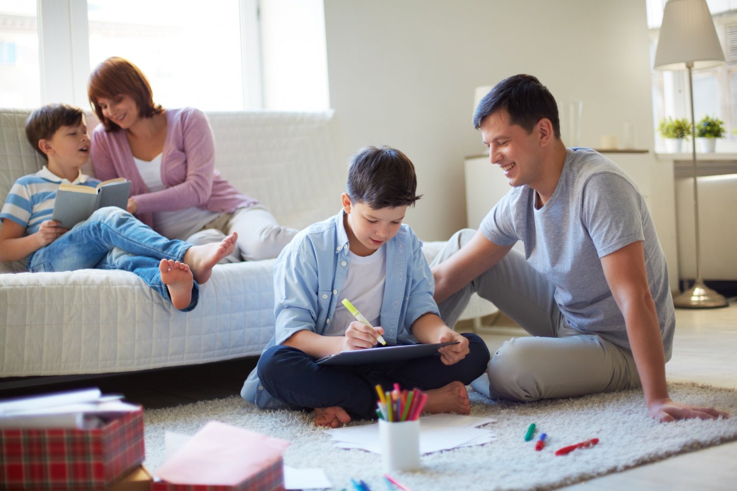 parents and kids smiling on a living room rug with a stack of board game boxes