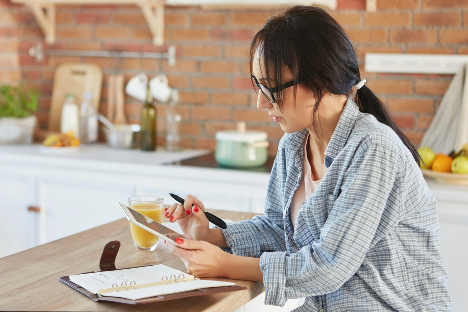  person journaling at a kitchen table in morning light, calm scene that suggests inner reflection and priority setting]