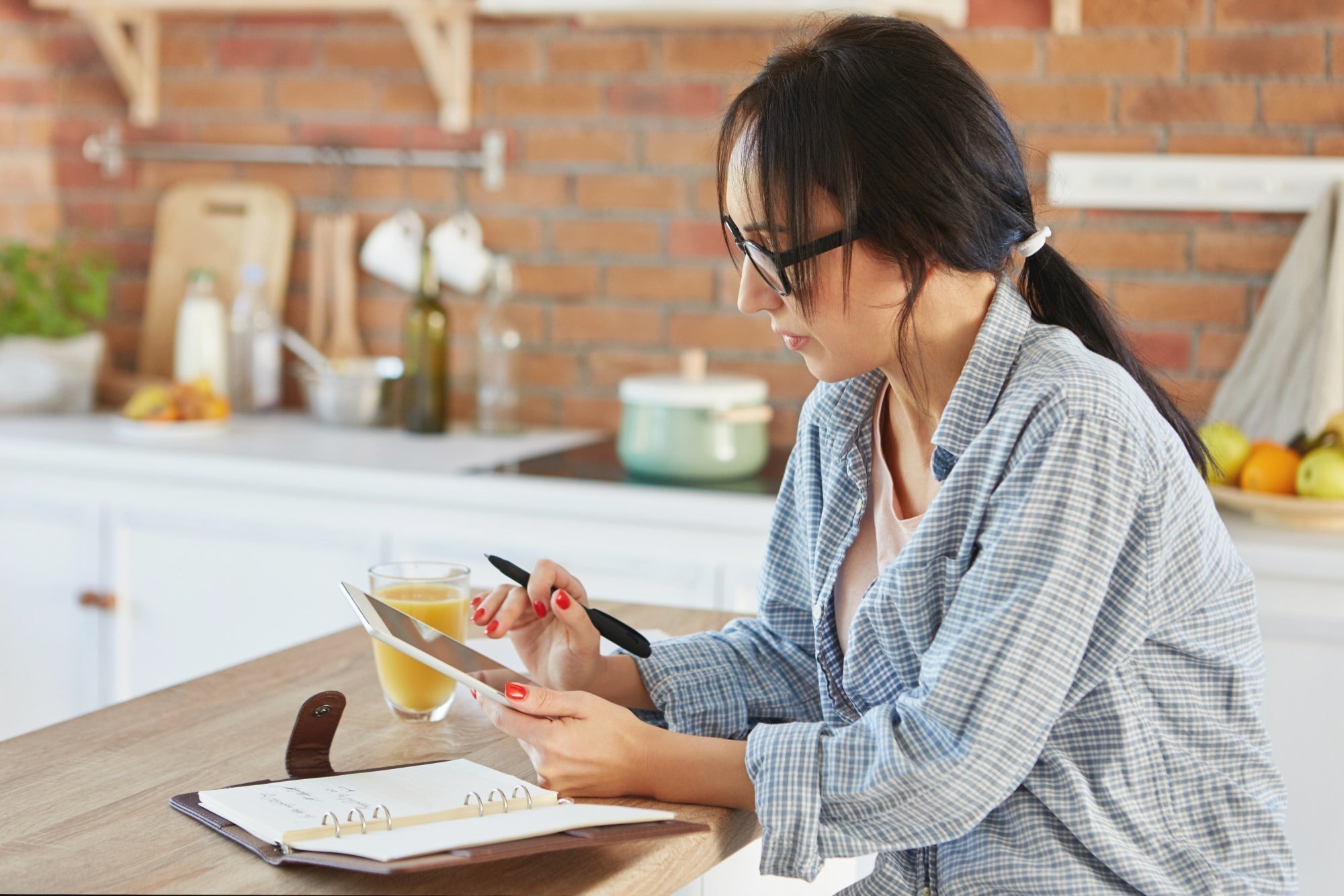  person journaling at a kitchen table in morning light, calm scene that suggests inner reflection and priority setting]