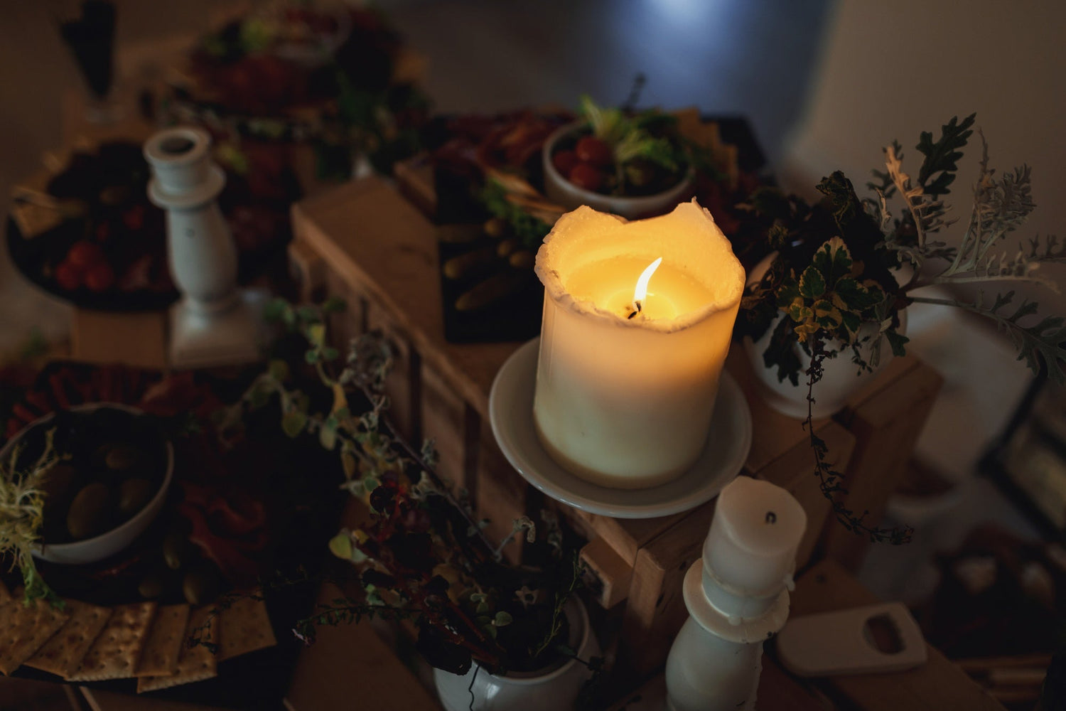 two candles side by side with soft reflections on a table